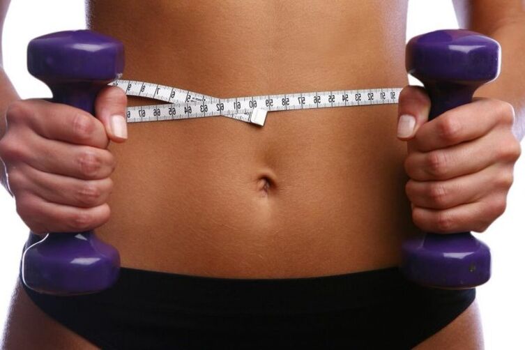 Haltères de fitness entre les mains d'une fille en forme
